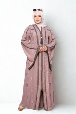 Elegant mauve embroidered abaya with floral patterns and front tassel detail, styled with hijab and sunglasses.