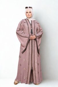Elegant mauve embroidered abaya with floral patterns and front tassel detail, styled with hijab and sunglasses.